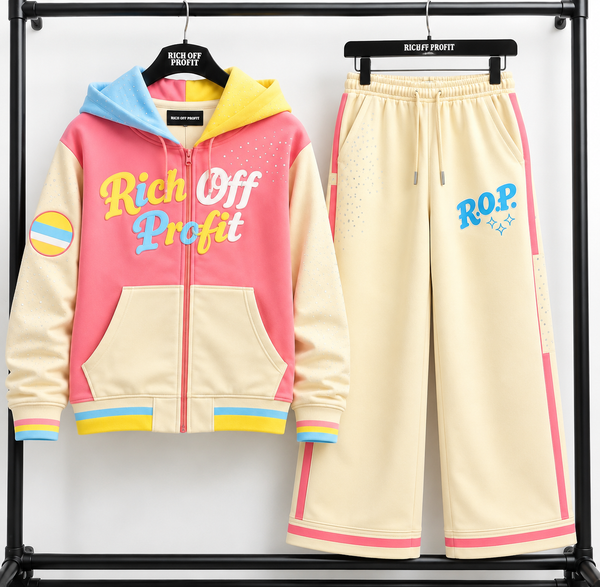 Rich Off Profit pastel zip hoodie and cream wide-leg pants with blue R.O.P. graphic, pink side stripes and rhinestone accents on a black rack